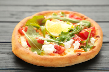 Margherita Italian pizza with cheese and tomato garnished with on black wooden table
