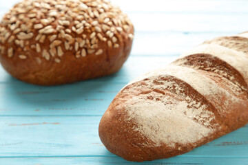 Fresh baked dark bread on blue wooden background with copy space.