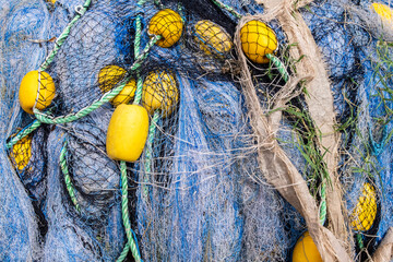 yellow and blue Fishing nets still life background pattern. Fishermen tackle, ropes and fishnets, piled on a wharf. Close up texture. Fresh fish from the sea.