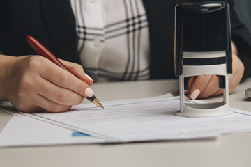 Close up on woman's notary public hand stamping the document. Notary public concept.