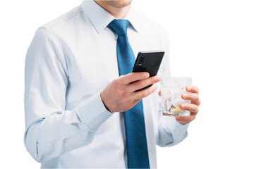 A guy in a white shirt and blue tie on a white background. A man looks at the phone screen and holds a glass with a cocktail.