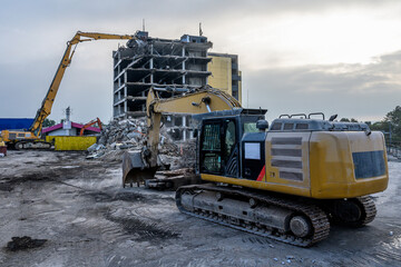 Dawn time Building House Demolition site Excavator with hydraulic crasher machine and yellow...