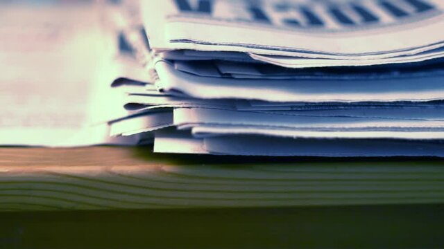 A stack of Old Newspapers with Articles and News on the Desk in the Office