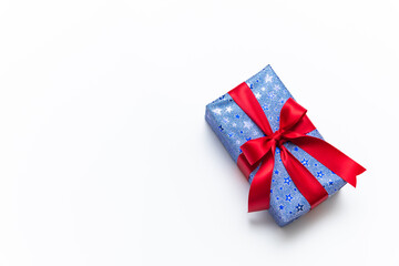 Blue gift box with red ribbons isolated on white background
