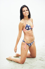 Obraz premium Young sexy woman on the beach in the swimsuit