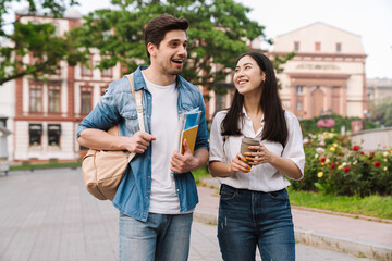 Image of couple talking and drinking coffee takeaway while walking