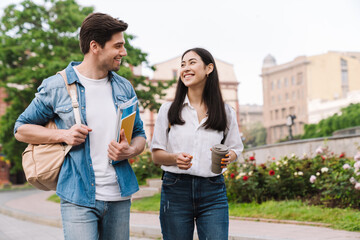 Image of couple talking and drinking coffee takeaway while walking