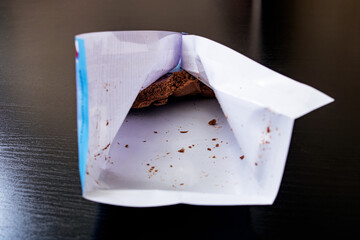 Eaten chocolate in the package on wooden background