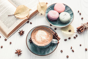 Coffee cup, macaroons and book on white background 