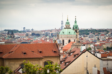 Fototapeta na wymiar View of red roofs of Prague along with St. Nicholas church and Zizkov tower