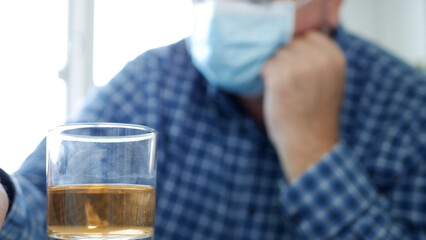 Drunk Person with Protection Mask on His Face Drink a Glass with Alcohol in a Bar