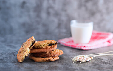 Stacked home made cookie view with a glass of milk and wheat spike studio shot