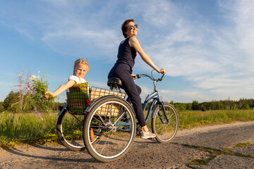 Young adult caucasian mom enjoy having leisure fun riding bicycle with cute adorable blond daughter...