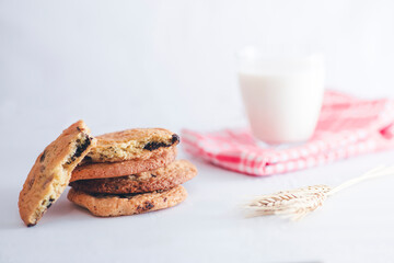 Stacked home made cookie view with a glass of milk and wheat spike studio shot