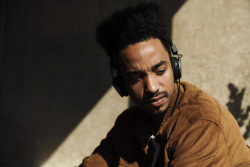 Photo closeup of serious african american man using headphones
