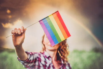 woman holding rainbow flag rainbow in the sky  LGBT rights