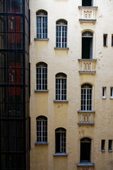 Widok na fasadę starej kamienicy z oknami - obrazy, fototapety, plakaty
