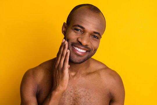 Closeup Photo Of Cheerful Dark Skin Guy Good Mood Hold Arm On Cheek Look Mirror Amazing After Shaving Lotion Result Naked Muscle Body Isolated Bright Yellow Color Background