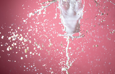 Splashing milk on a pink background.