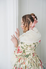 Beautiful woman in long medieval dress in the hall. Back pose
