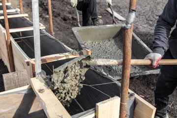 Pouring concrete into the foundation at a construction site.