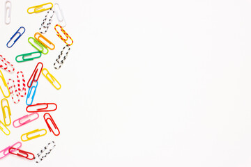 A lot of colored paper clips lie on a white background. Presentation Slide