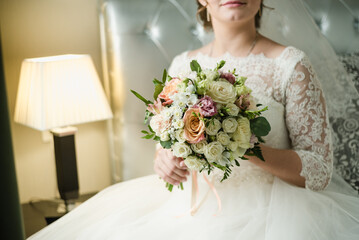 bride holds a bouquet, the bride's bouquet, bridal bouquet of roses, bride in a wedding dress, wedding day, bride fees