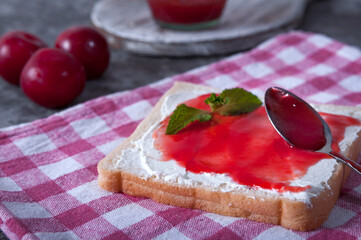 Breakfast from a sandwich with cheese and plum jam. Plum jam for breakfast. Tasty breakfast.