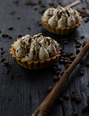 Cappuccino tart with cinnamon sticks and coffee beans on rustic wooden table