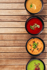 flat lay of cream vegetable soups on wooden table