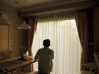 A man sitting by the window stay at home