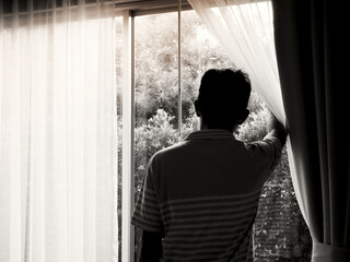 A man standing by the window stay at home