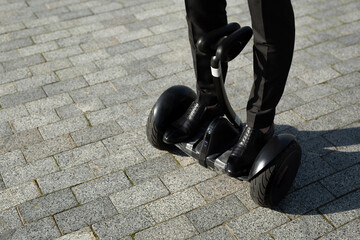 Man legs riding electric hoverboard in park