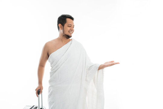 asian male with ihram presenting copyspace. hajj and umrah man concept