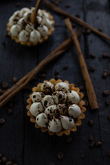 Cappuccino tart with cinnamon sticks and coffee beans on rustic wooden table
