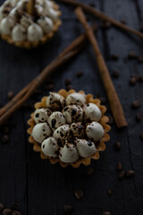 Cappuccino tart with cinnamon sticks and coffee beans on rustic wooden table