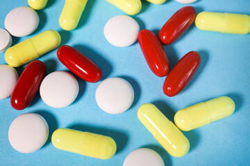 Pills, tablets and glass of water on blue background top view. Medical pharmacy concept.multi-colored pills on a blue background. view from above