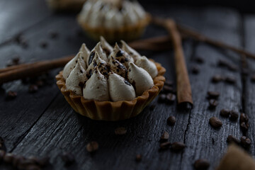 Cappuccino tart with cinnamon sticks and coffee beans on rustic wooden table