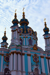 Fototapeta na wymiar Astonishing detailed view of ancient Saint Andrew Church against blue sky at sunny spring morning. Baroque style in ancient architecture. Architectural icon of the city of Kyiv, Ukraine