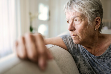 Portrait Of Senior Woman On Sofa Suffering From Depression