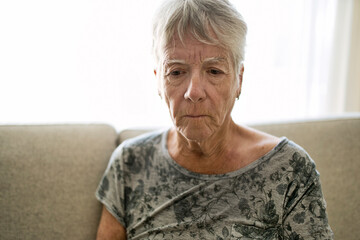 Portrait Of Senior Woman On Sofa Suffering From Depression