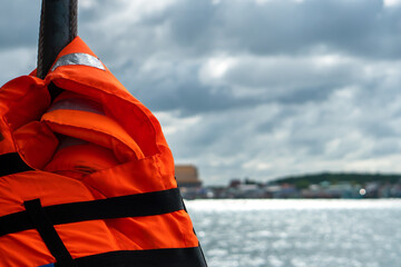 Blurred background of water sea with emergency safety swimming orange life jacket vest use for...
