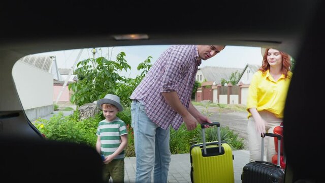 summer vacation, happy husband and wife with their beloved son load family travel bags in car for vacation trip