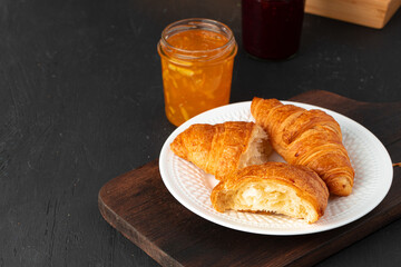 Fresh croissants on wooden board close up