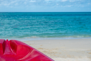 Background of beautiful summer holiday vacation on white clean sand beach clear sea water quite wave with red Kayak boat for fun active activity 