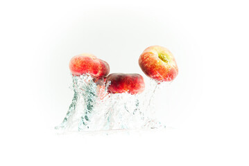 Bunch of doughnut peaches isolated on white, splashing into water.