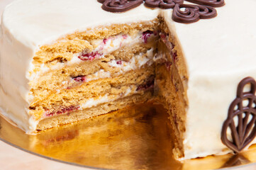 White cake four layers on golden support with chocolate shapes decoration
