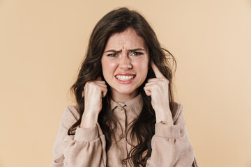 Image of unhappy brunette nice woman plugging her ears
