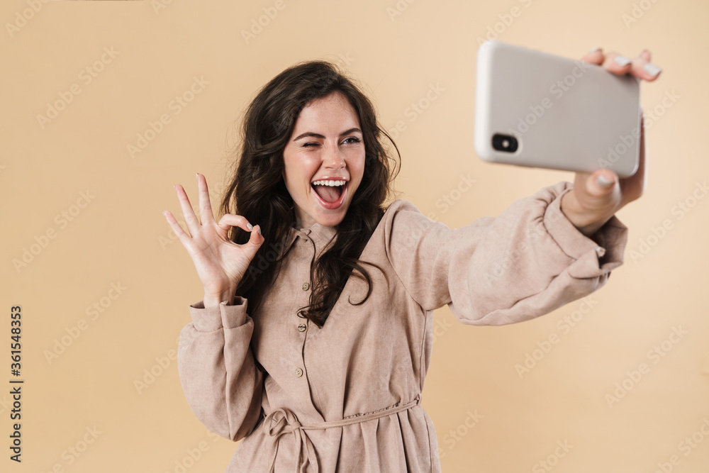 Sticker Image of woman gesturing ok sign while taking selfie on cellphone