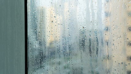 Closeup of window in humid weather with leaks and drops on the glass